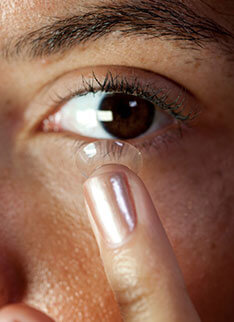 Putting on contact lens on eye